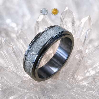 A polished metallic spinning ring from Anxiety Rings Australia with a textured, sparkly silver-gray inlay band, displayed on a cluster of clear quartz crystals. Two small circular inset images at the top show the ring in silver and gold-tone settings.