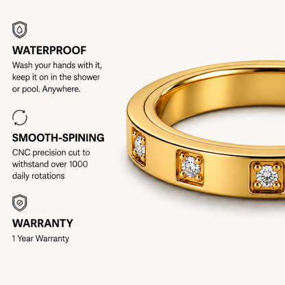 Gold spinning ring from Anxiety Rings Australia with three square-set clear gemstones on a light beige background, with text callouts reading WATERPROOF, SMOOTH-SPINING, and WARRANTY.