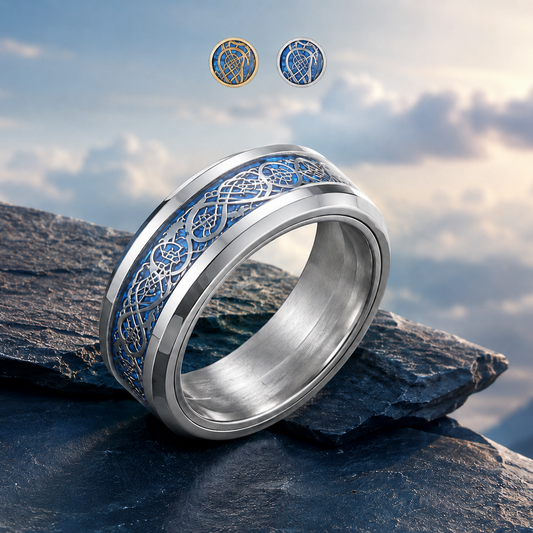 A silver-toned spinning ring from Anxiety Rings Australia with an intricate blue and silver Celtic knot pattern, resting on dark slate rocks with a cloudy sky background showing the colour options of silver or gold pattern.