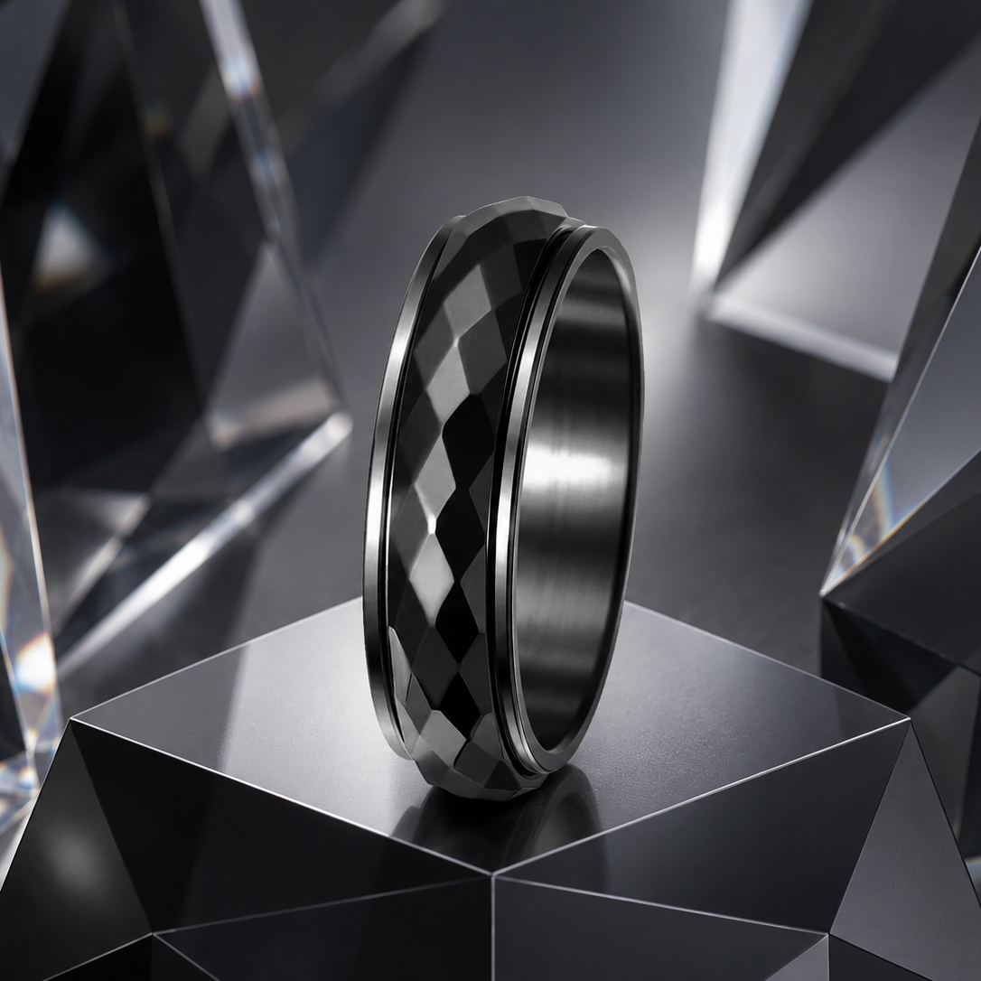 A black band spinning ring from Anxiety Rings Australia with a faceted diamond-cut inlay, standing upright on a dark geometric pedestal surrounded by faceted crystal-like structures.