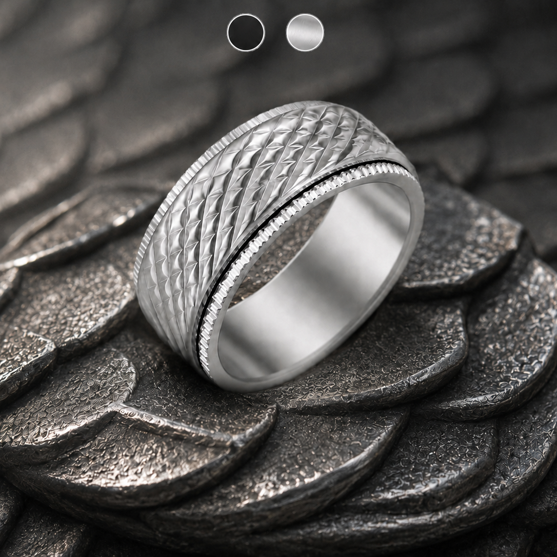 A silver-toned textured spinning ring from Anxiety Rings Australia with a diamond-patterned band and a beaded inner edge, displayed on a dark textured scale-like surface.
