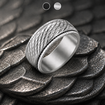 A silver-toned textured spinning ring from Anxiety Rings Australia with a diamond-patterned band and a beaded inner edge, displayed on a dark textured scale-like surface.